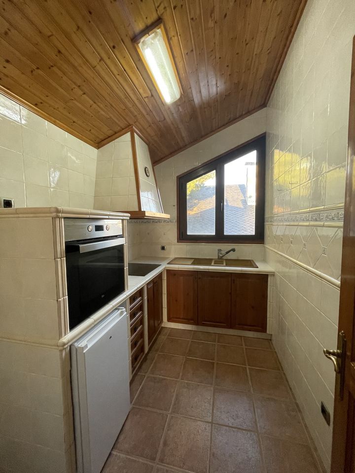 Cocina rústica bajo cubierta de madera