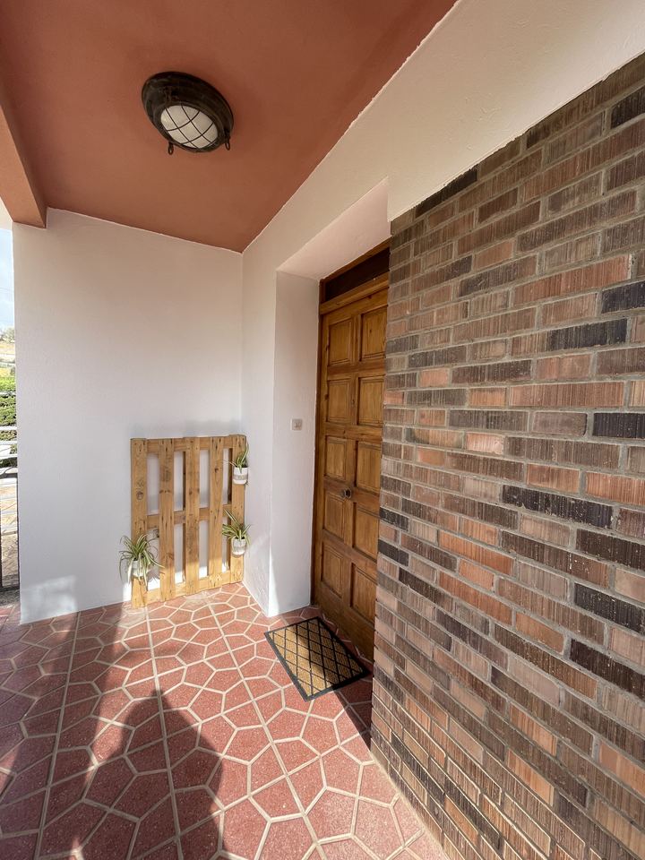 Puerta de entrada con pared de ladrillo visto